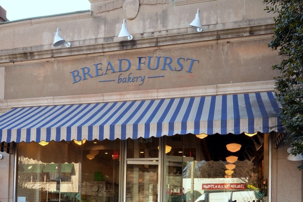 the front of a breadfruit bakery with a blue and white striped canopy