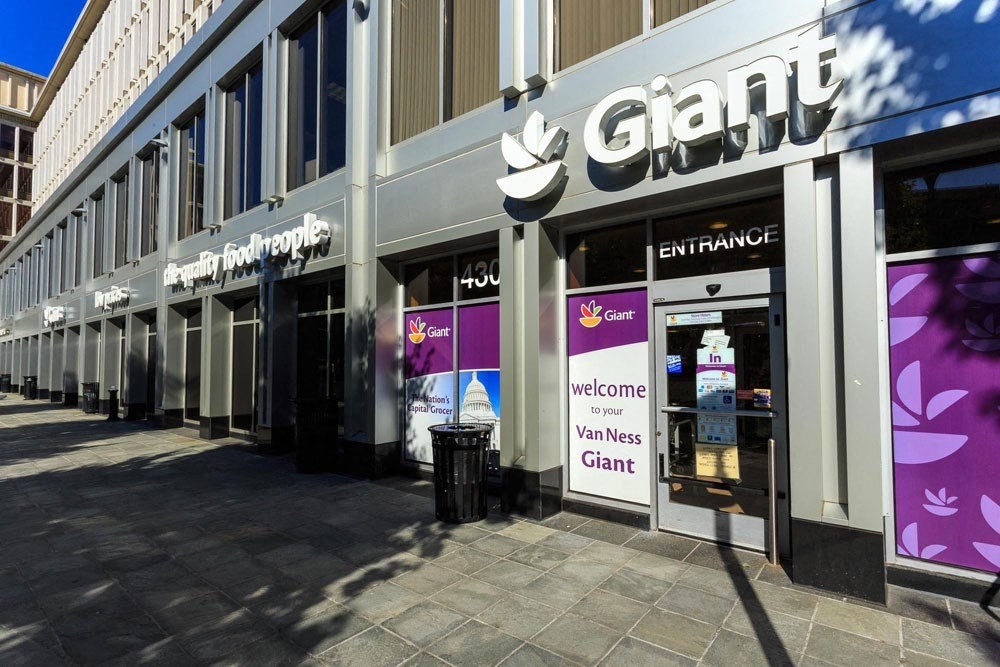 a store front of a building with purple and white signs at The Chesapeake Apartments, Washington, DC