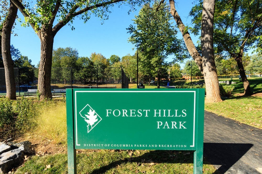 a sign for forest hills park in front of trees at The Chesapeake Apartments, Washington DC
