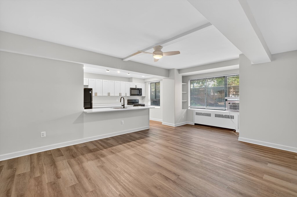A room with a ceiling fan and wooden flooring.
