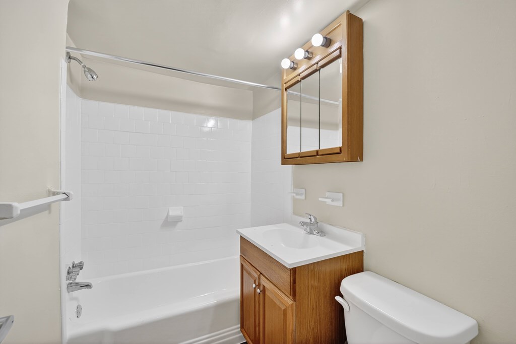 A white bathroom with a sink, toilet and bathtub.