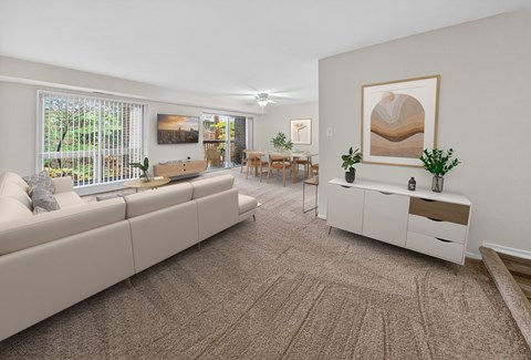 A living room with a large couch, a coffee table, and a painting on the wall.