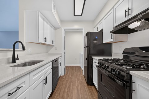 A kitchen with white cabinets and a black stove top oven.