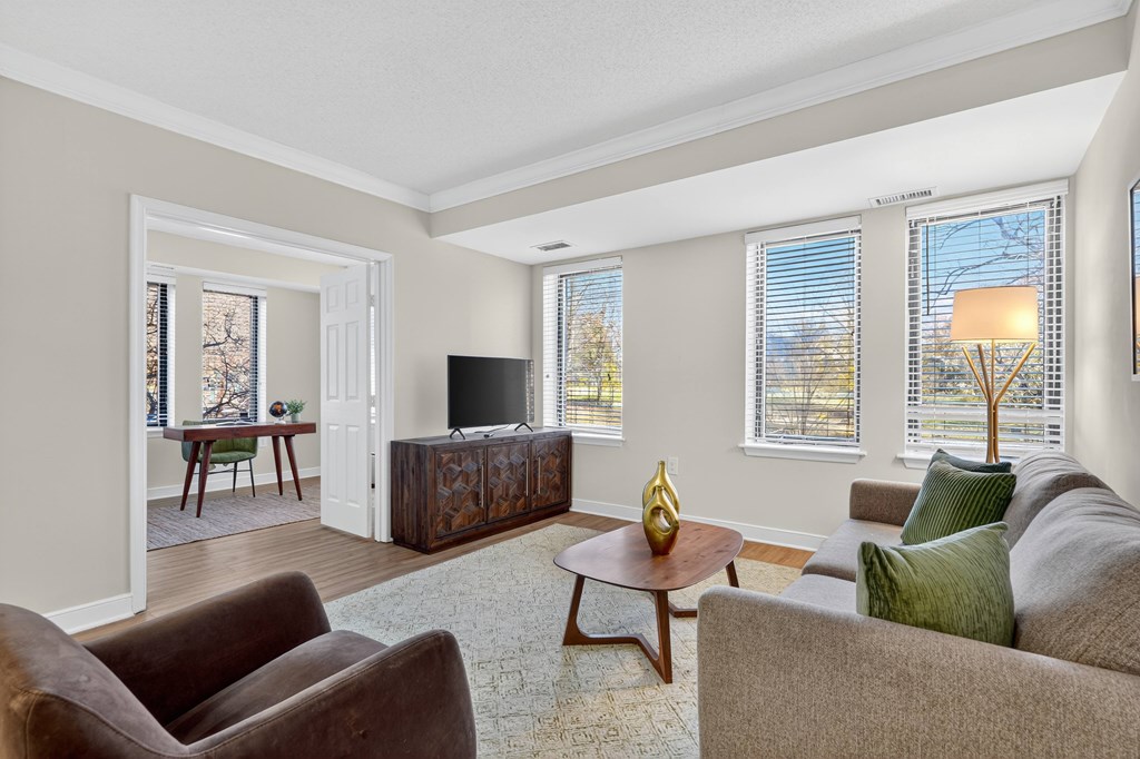 A living room with a brown couch, a wooden coffee table, and a flat screen TV.