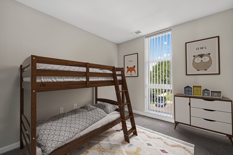 A bedroom with a bunk bed and a dresser.