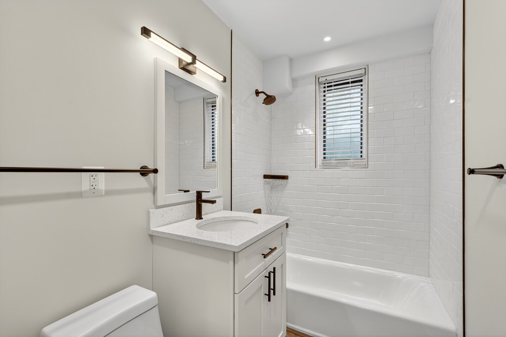 A white bathroom with a toilet, sink, and bathtub.