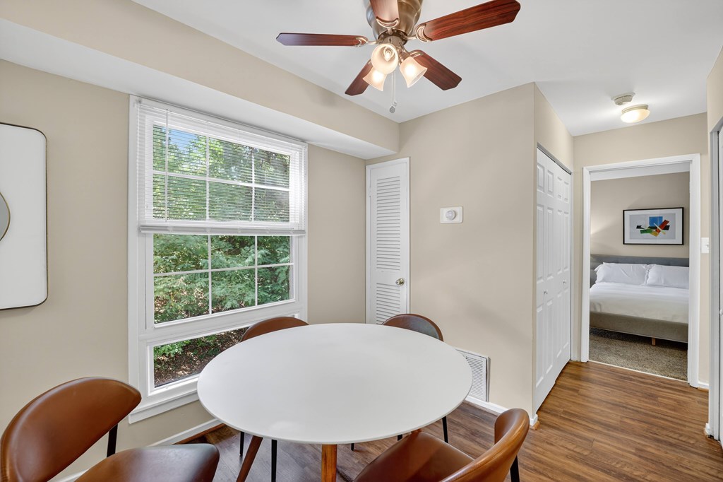 A room with a table and chairs and a window.