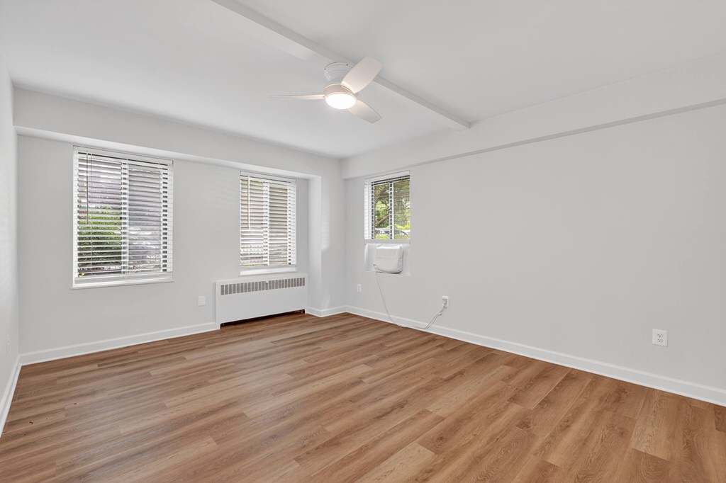 A room with wooden flooring and white walls.