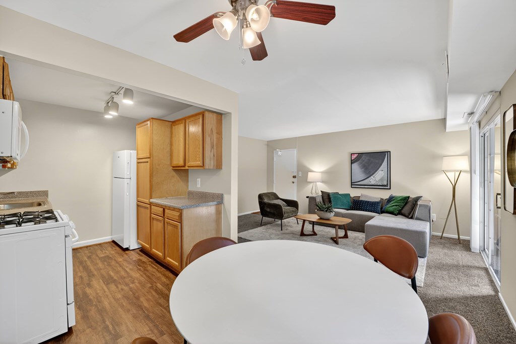 A living room with a white table and brown chairs.