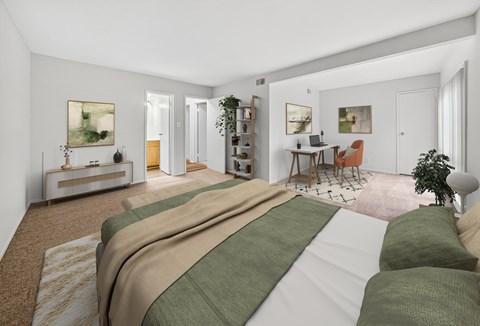 A bedroom with a large bed and a desk with a chair.