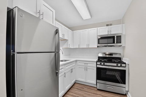 A kitchen with a stainless steel refrigerator and oven.
