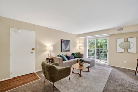 A living room with a green chair and a white couch.