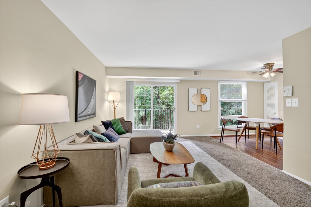 A living room with a couch, a chair, a table, and a lamp.