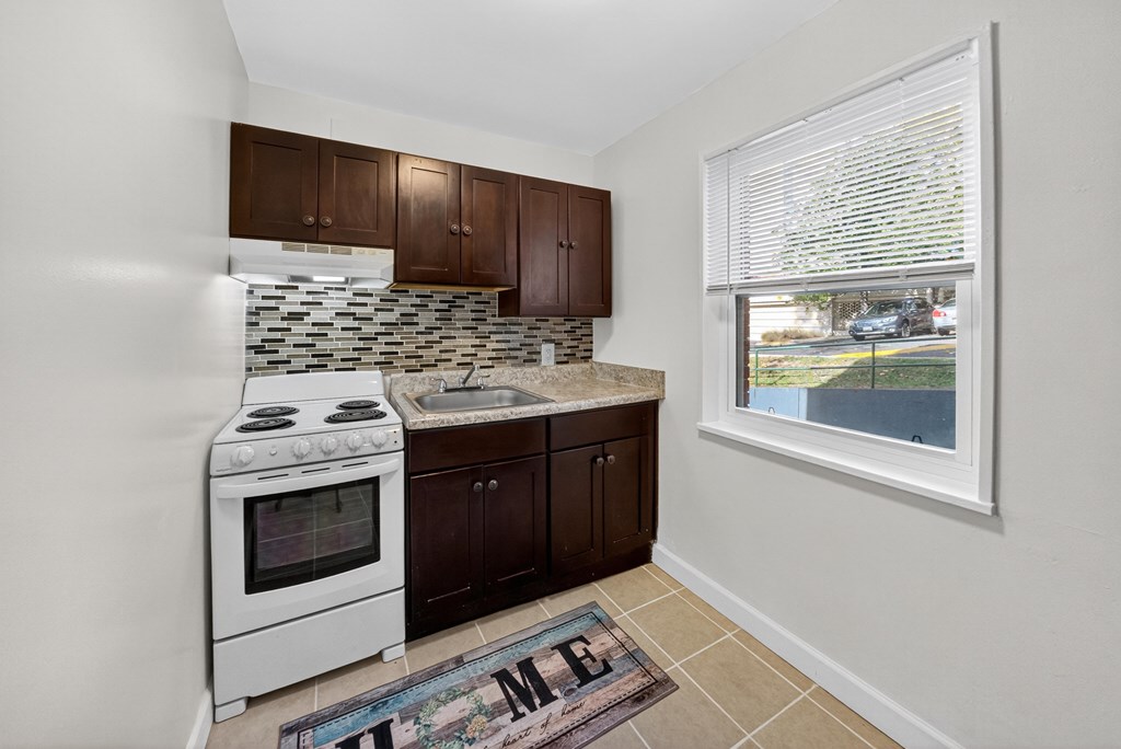 A kitchen with white appliances and brown cabinets.