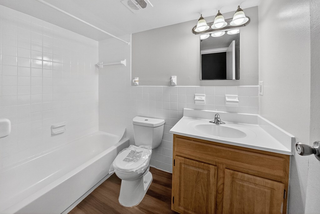 A white bathroom with a toilet, sink, and bathtub.