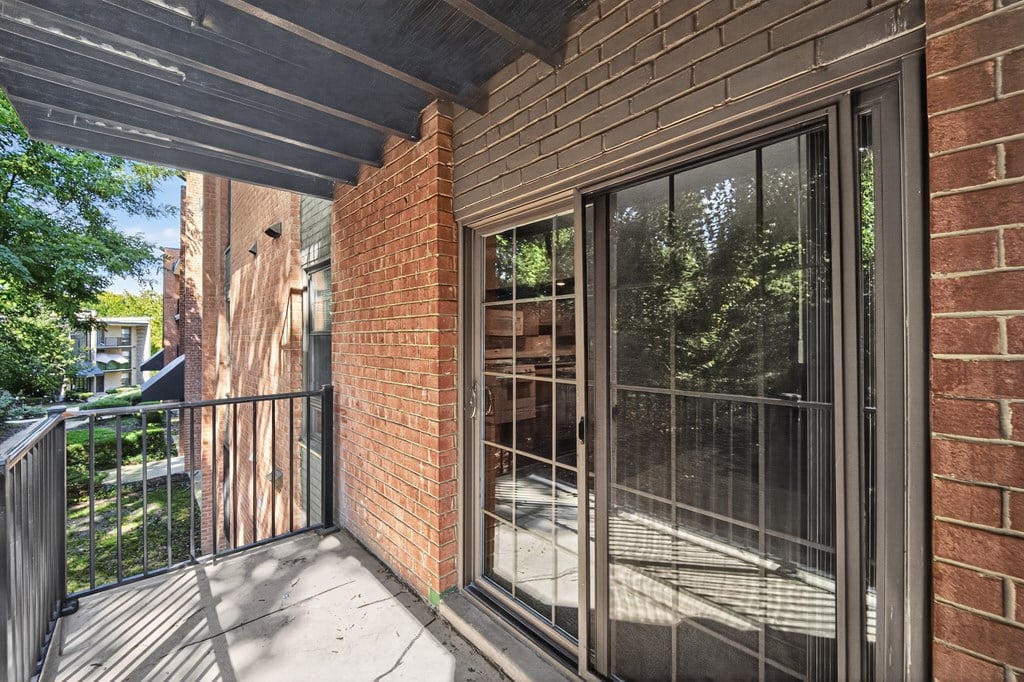 A balcony with a black railing and a glass door.