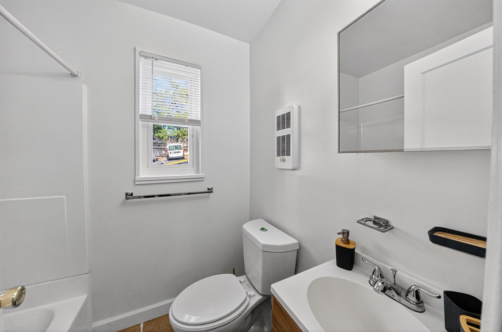 A white toilet sits next to a sink in a small bathroom.