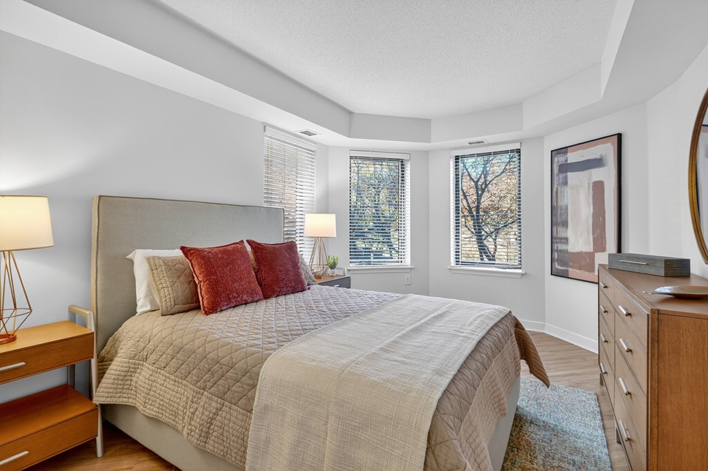 A bedroom with a large bed and a wooden dresser.