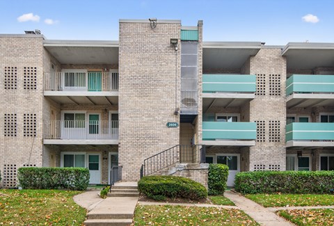 Apartment building with a green awning and a mailbox on the front.