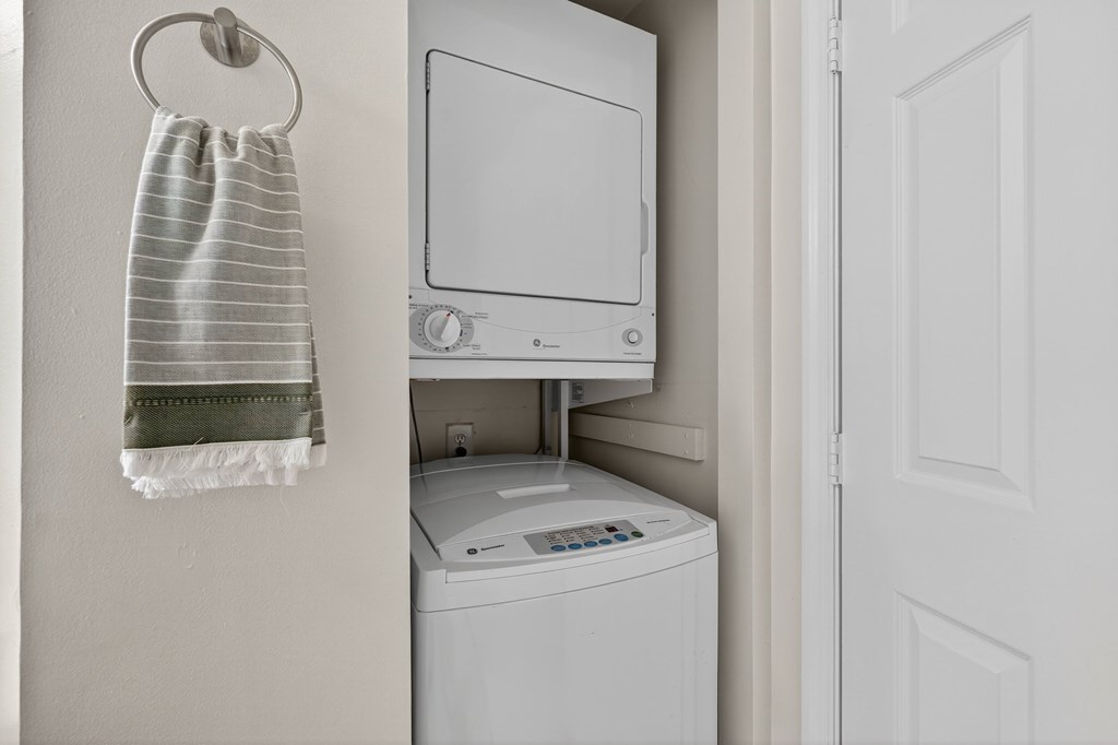 A white washing machine is in a small laundry room.