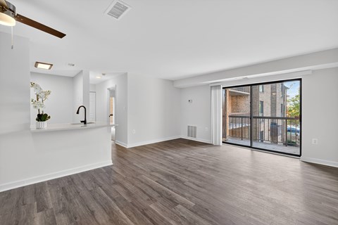 A spacious room with a ceiling fan and sliding glass doors.