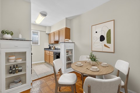 A kitchen with a table and chairs in front of it.