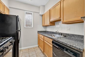 A kitchen with a black fridge, stove, and oven.