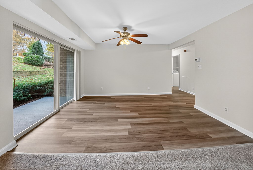A room with wooden flooring and a ceiling fan.