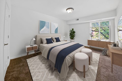 A bedroom with a large bed and a window overlooking trees.