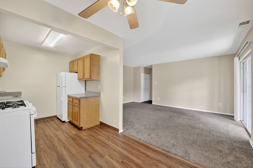 A kitchen with a white stove and wooden cabinets.