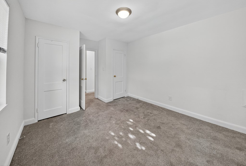 A room with carpeted floor and white walls.