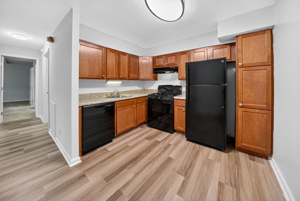 A kitchen with wooden cabinets and black appliances.