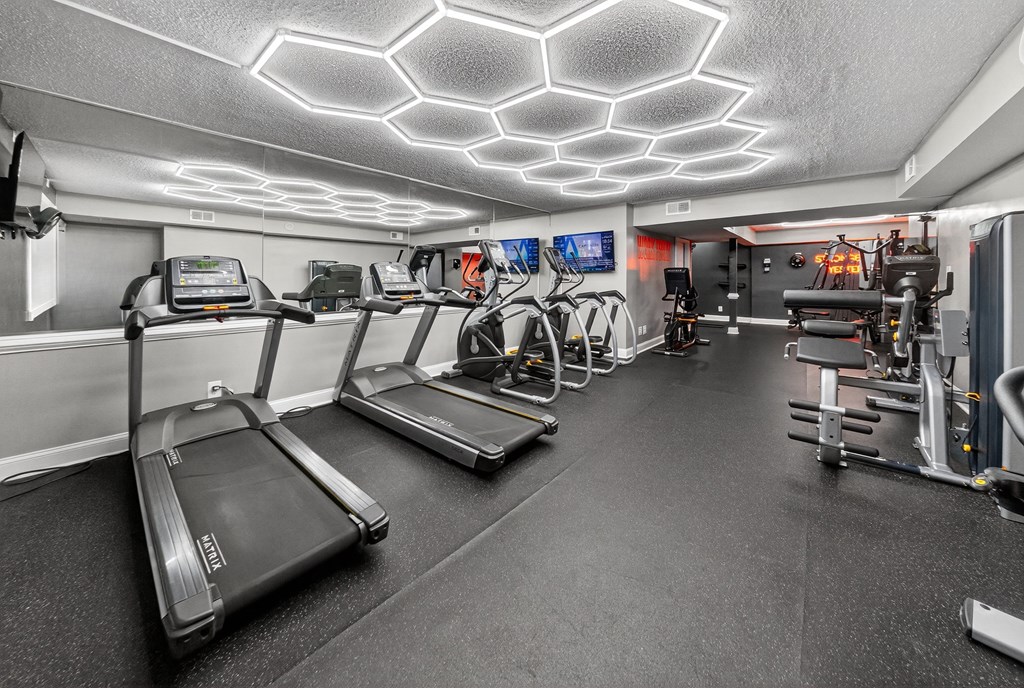 A gym with treadmills, exercise bikes, and other equipment.