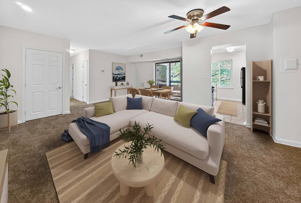 A living room with a white couch and a ceiling fan.