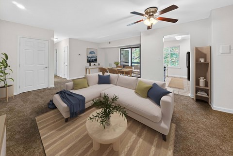 A living room with a white couch and a ceiling fan.