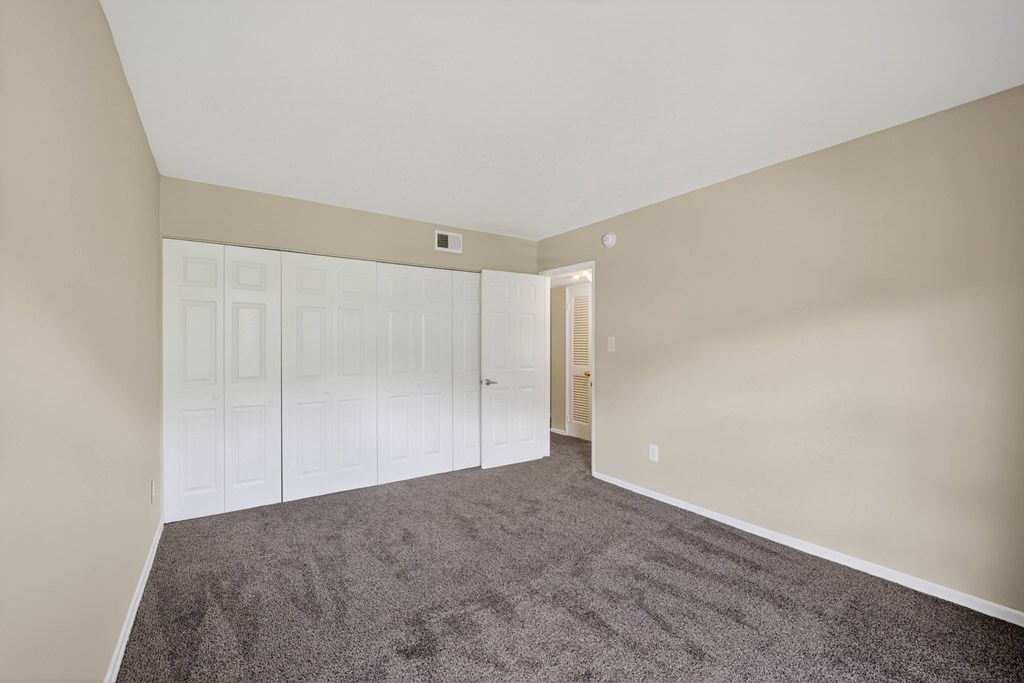 A room with a carpeted floor and white walls.