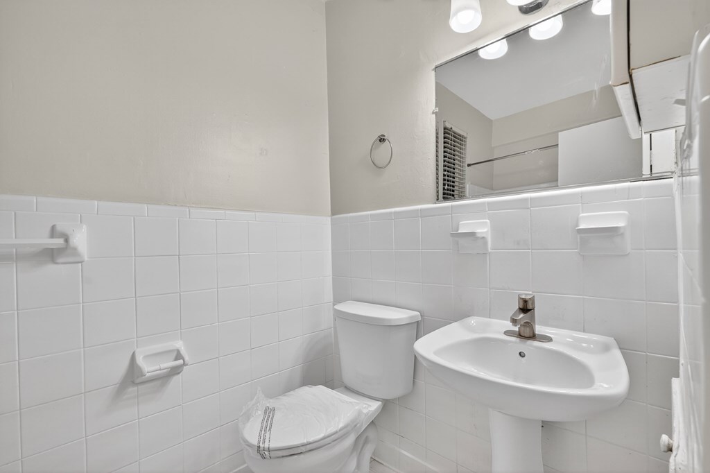 A white toilet and sink in a bathroom.