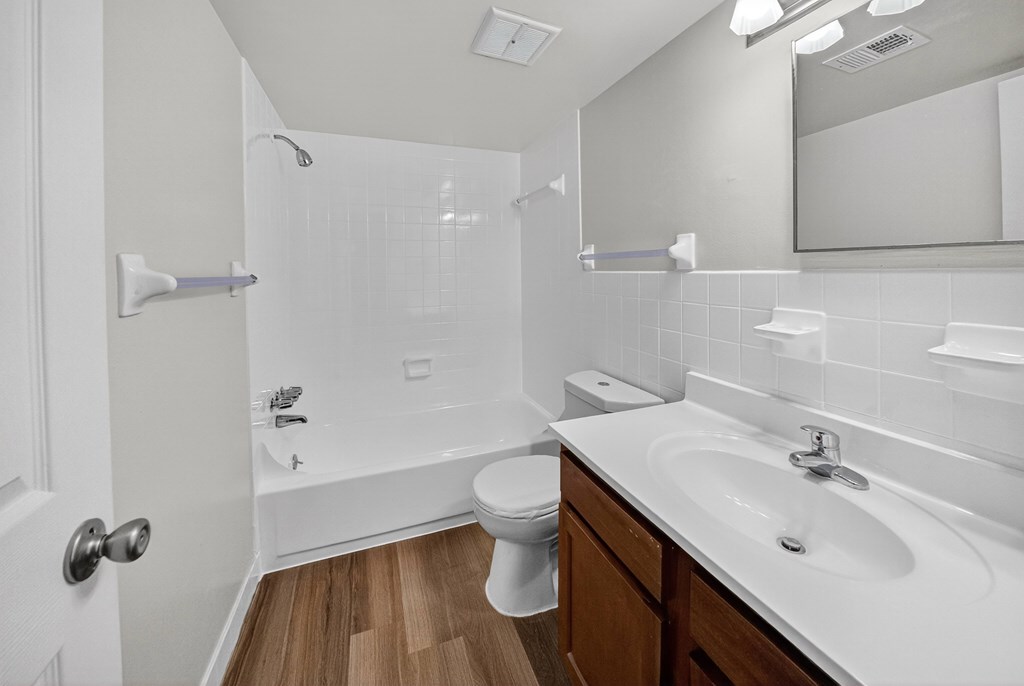 A white bathroom with a toilet, sink, and shower.