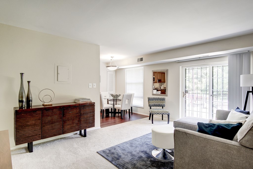 A living room with a grey couch and a wooden cabinet.