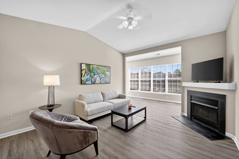 A living room with a fireplace and a painting on the wall.