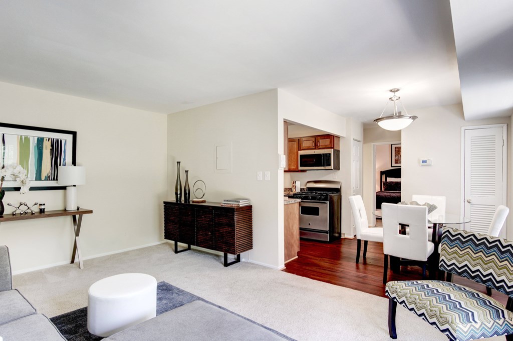 A modern living room with a white sofa and a grey ottoman.