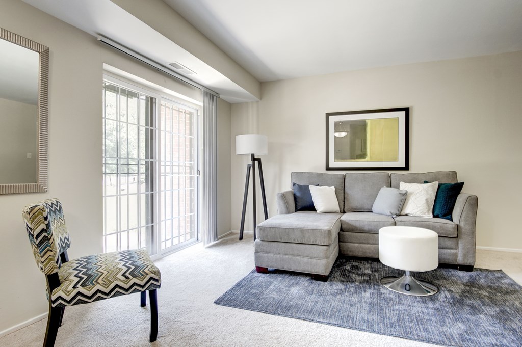 A living room with a grey couch, a chair, and a floor lamp.