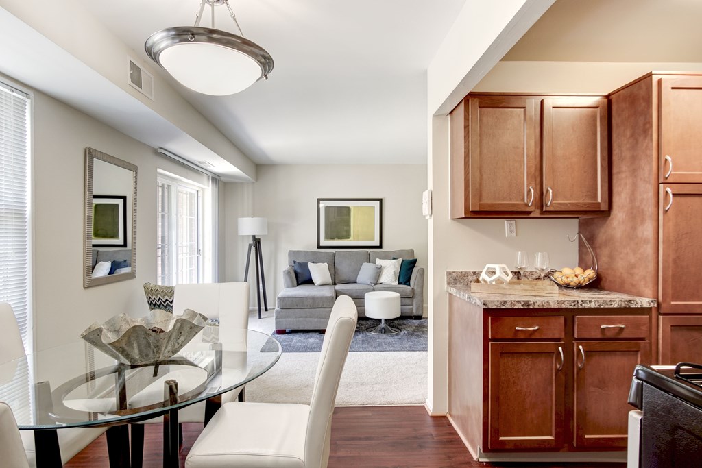 A modern kitchen with a glass table and chairs.