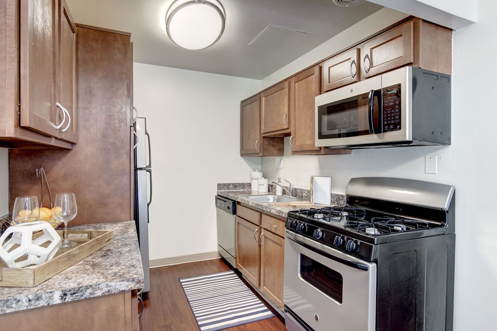 A kitchen with a black stove top oven and a microwave above it.