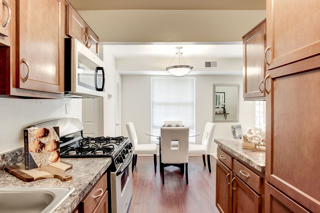 A kitchen with wooden cabinets and a black stove top.