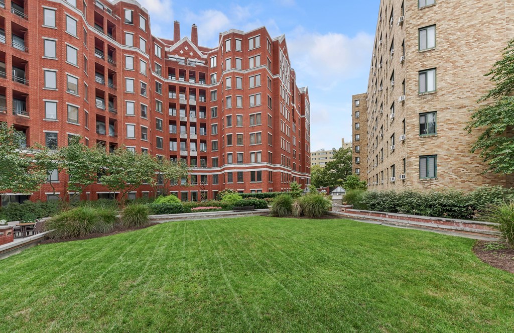 A red brick building with a green lawn in front.