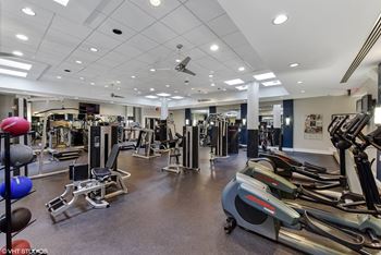 a gym with cardio equipment and weights on the floor of a building at The Chesapeake, Washington, DC 20008