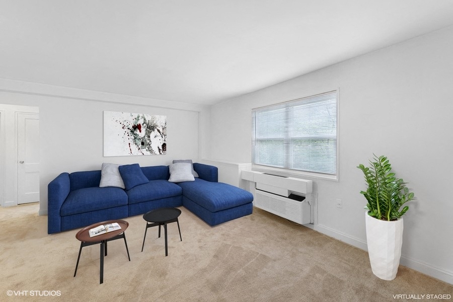 a living room with a blue couch and a window