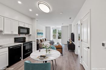 A modern kitchen with a dining table set for two.