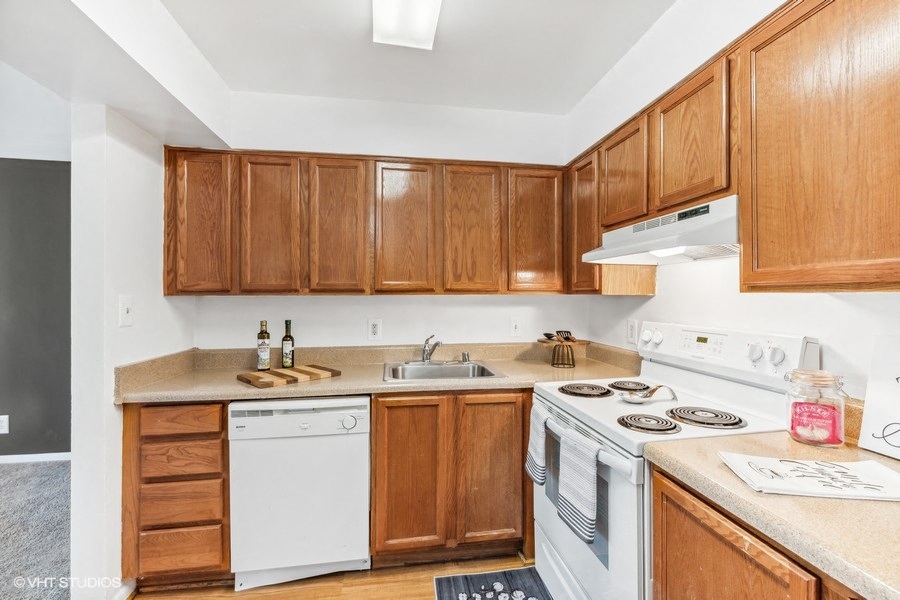 a kitchen with white appliances and wooden cabinets